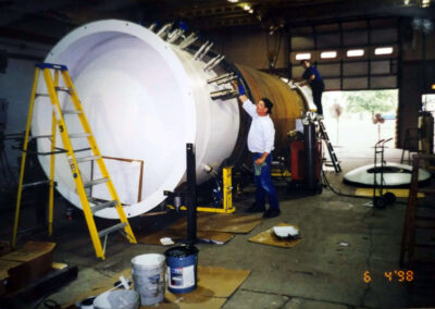 This is an image of manufacturing a cold box purification system. Painting Exterior of Vacuum Vessel in Image